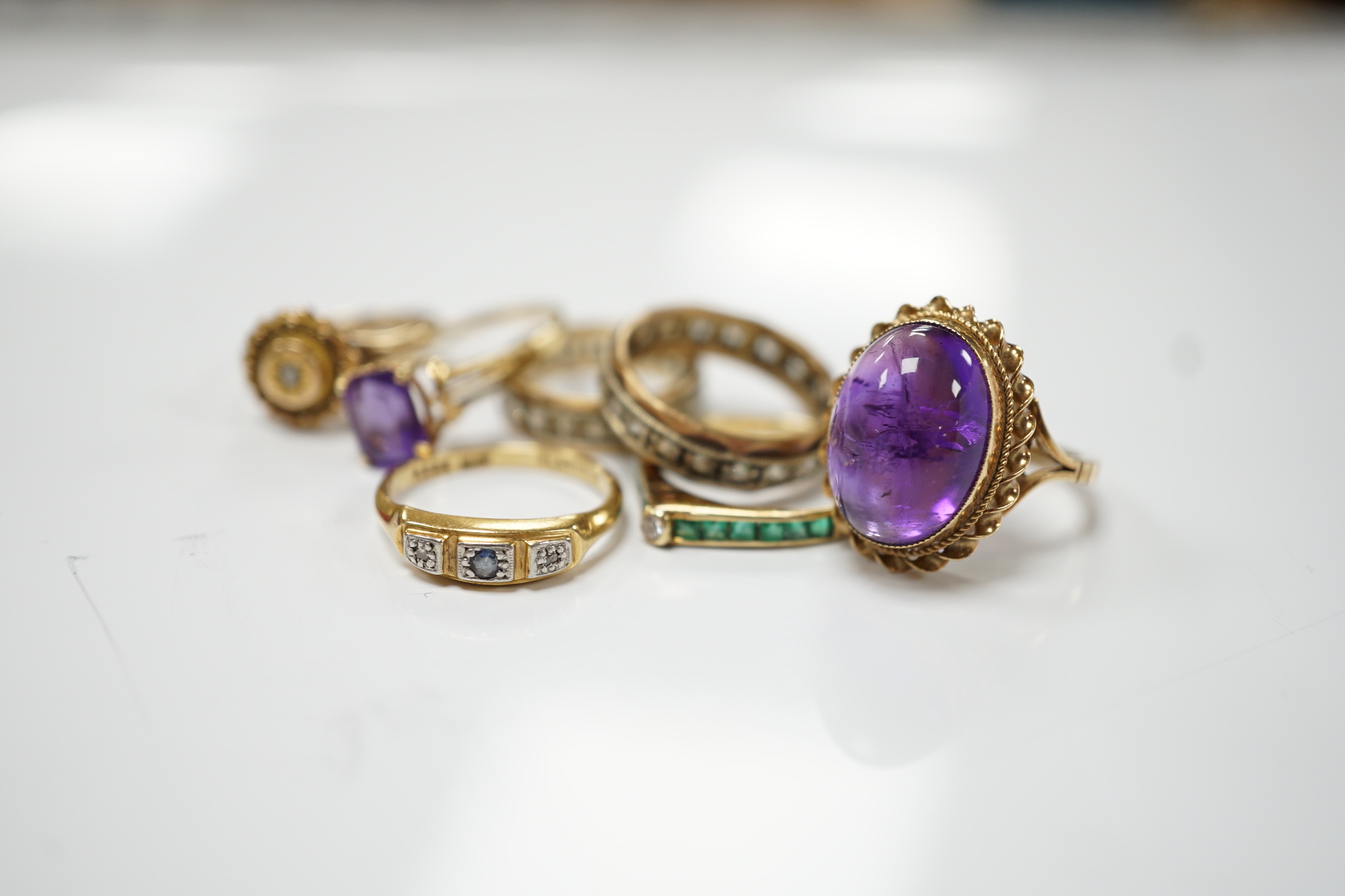 Five assorted 9ct and gems set rings including cabochon amethyst, gross weight 15.1 grams, an 18ct and gem set ring and a 585 emerald and diamond set ring